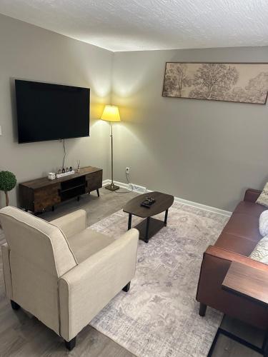 a living room with a couch and a flat screen tv at Comfortable and Calm Stay in Columbus in Columbus