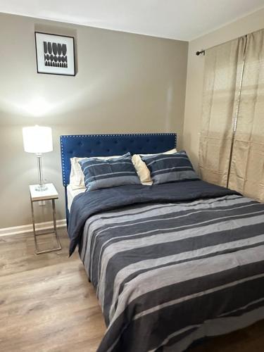 a bed with a blue headboard in a bedroom at Comfortable and Calm Stay in Columbus in Columbus