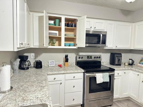 a kitchen with white cabinets and a stove top oven at Comfortable and Calm Stay in Columbus in Columbus