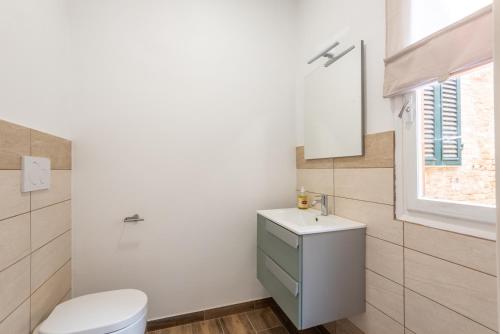 a bathroom with a white toilet and a sink at L'arco del pellegrino in Monteroni dʼArbia