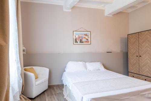 a small bedroom with a bed and a chair at L'arco del pellegrino in Monteroni dʼArbia