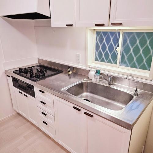 a kitchen with a sink and a stove at Itoshima STAY YAMAGA Keya in Itoshima