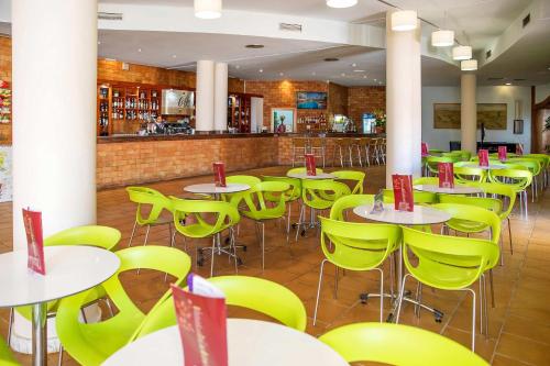 a dining room with tables and yellow chairs at Hotel Servigroup Marina Mar in Mojácar