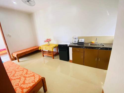 Habitación con cocina con fregadero y mesa. en Enjoy and have fun while having your vacation, come book this place, en Bayawan