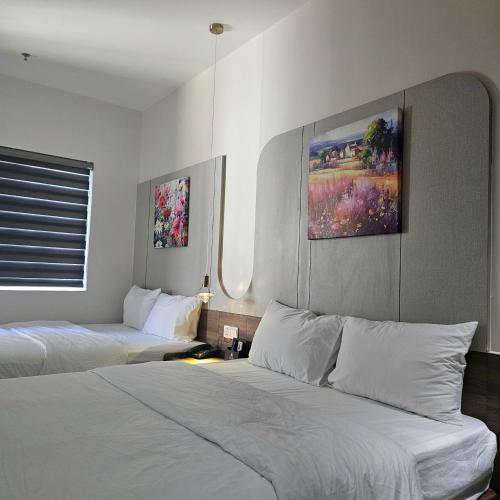 a hotel room with two beds and a window at RosaLie Quảng Bình Hotel in Dong Hoi