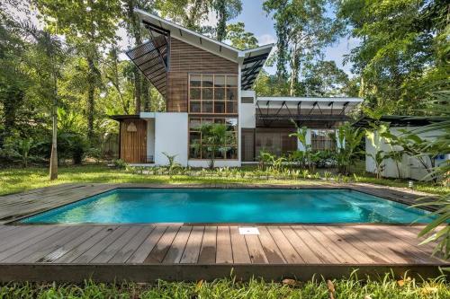 a house with a swimming pool and a wooden deck at Porto Alegre in Punta Uva
