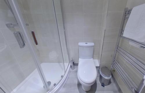 a small bathroom with a toilet and a shower at Victoria House - Deluxe Studios in Coventry City Centre, free parking, by COVSTAYS in Coventry