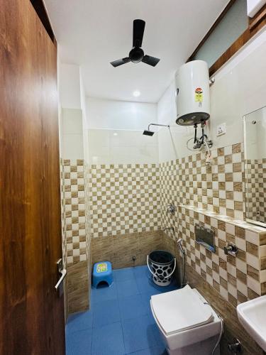 a bathroom with a toilet and a ceiling fan at Hotel Grand Central in Bulandshahr