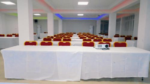 a large room with a white table and chairs at Hotel BKBG in Lomé