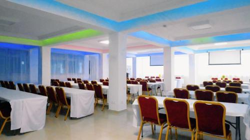 a conference room with tables and chairs and a green ceiling at Hotel BKBG in Lomé