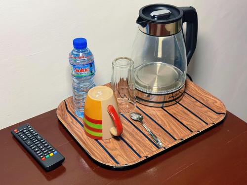a blender on a wooden tray with a bottle of water at Hotel BKBG in Lomé