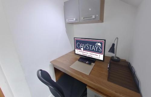 a desk with a computer sitting on top of it at Victoria House - Deluxe Studios in Coventry City Centre, free parking, by COVSTAYS in Coventry