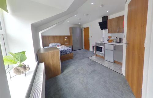 a bedroom with a bed and a kitchen in a room at Victoria House - Deluxe Studios in Coventry City Centre, free parking, by COVSTAYS in Coventry