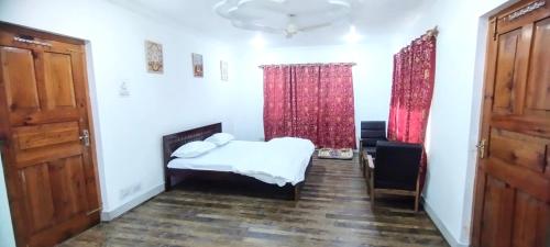 a room with a bed and two windows with red curtains at Greenoriva - D2 - Greenery & Peace in Srinagar