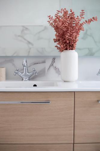 a bathroom sink with a vase with a plant in it at L'Olivier in Touët-sur-Var