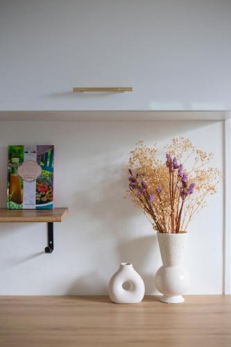 a white vase with flowers in it on a table at L'Olivier in Touët-sur-Var