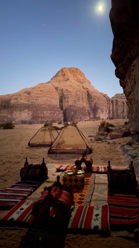 a group of people laying on the sand in the desert at Wadi Rum Magic Camp in Wadi Rum