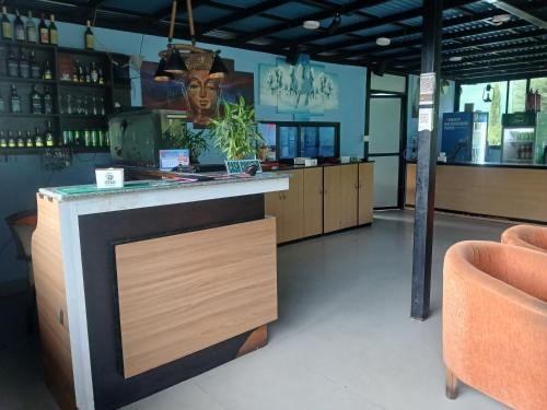 un bar avec un comptoir dans une pièce avec des chaises dans l'établissement The sumeru jungle resort, à Bhaktapur