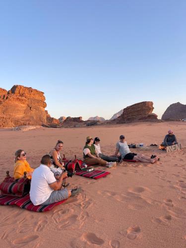 a group of people sitting on the beach at Wadi Rum Magic Camp in Wadi Rum