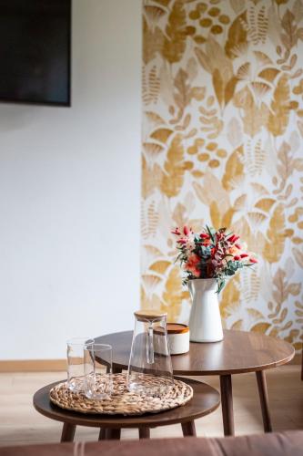 a table with two chairs and a vase with flowers at L'Olivier in Touët-sur-Var