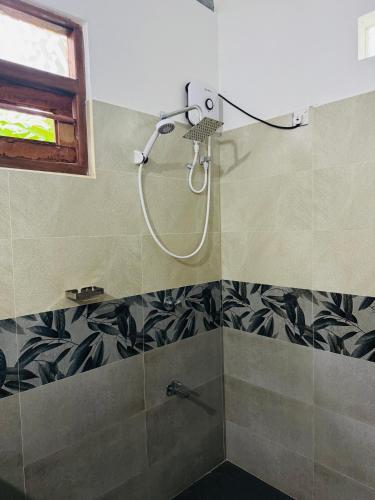a shower in a bathroom with a glass door at The La Nature Villa in Wadduwa