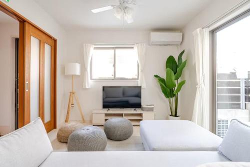 a living room with two white couches and a television at 天の浜Dojo ーThin no Hama Dojoー in Nanjo