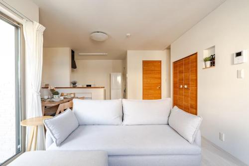 a living room with a white couch and a table at 天の浜Dojo ーThin no Hama Dojoー in Nanjo