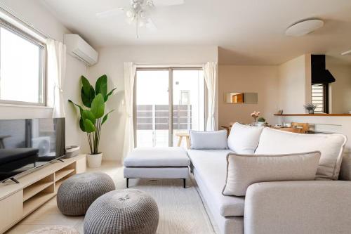 a living room with a couch and a tv at 天の浜Dojo ーThin no Hama Dojoー in Nanjo