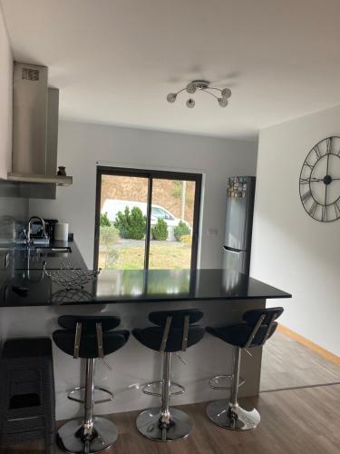 a kitchen with a black counter and bar stools at Zen Budas in Painzela