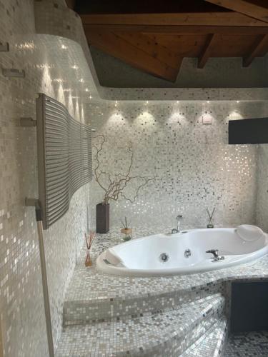 a bath tub in a bathroom with white tiles at La casetta di San siro in Milan