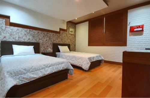 a hotel room with two beds in a bedroom at Taebaek Hotel Sorano in Taebaek
