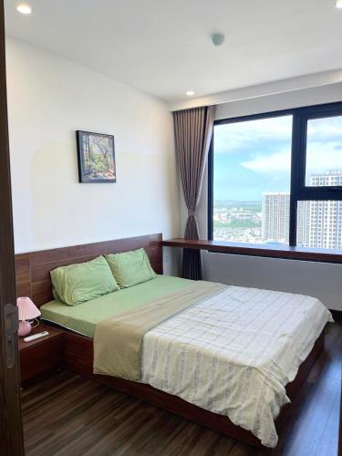 a bedroom with a bed and a large window at Na Mit HomeStay in Hai Phong