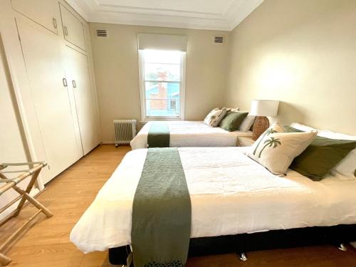 ein Schlafzimmer mit zwei Betten und einem Fenster in der Unterkunft RIVERBANK COTTAGE in Sussex inlet