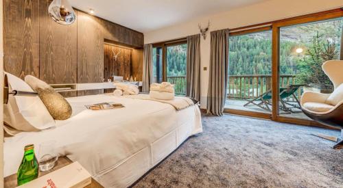 una camera da letto con un letto grande e una grande finestra di Chalet Les Sources De La Davie - Chalet LES SOURCES de la DAVIE services hôteliers MAE-8981 a Tignes