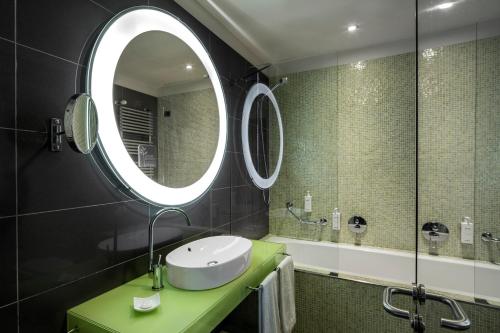 a bathroom with a sink and a mirror at UNA HOTELS T Hotel Cagliari in Cagliari