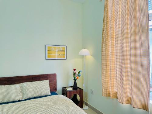 ein Schlafzimmer mit einem Bett und einem Fenster mit Vorhängen in der Unterkunft Tụi Mình homestay in Thôn Trường Giang