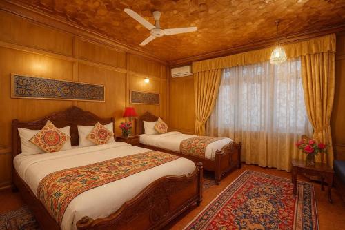 a bedroom with two beds and a window at Lake Victoria Houseboats in Srinagar