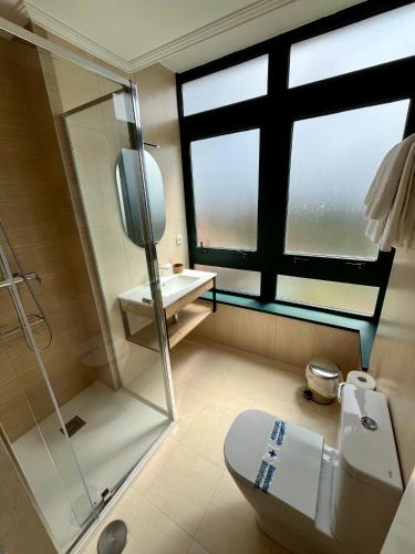 a bathroom with a shower and a toilet and a sink at Val de Serantes in Ferrol