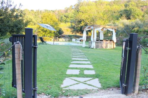 a garden with a gazebo and a stone path at Relax Guazza - Piscina a Comune - Parcheggio in Pieve a Maiano