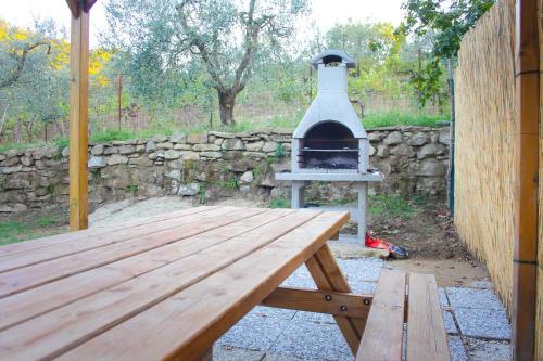 a wooden picnic table with a pizza oven on it at Relax Guazza - Piscina a Comune - Parcheggio in Pieve a Maiano