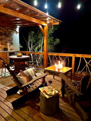 a wooden deck with a table and a fire pit at Santuá - Cabana Bellagio in Rio dos Cedros