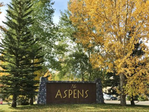 a sign for the aspes in a park with trees at RMR: Columbine 1011 Condo in The AspensWilsonWY in Wilson