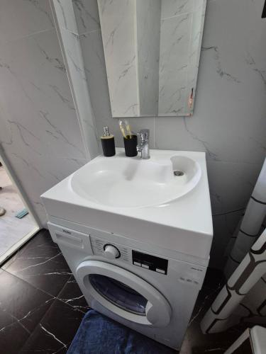 a bathroom with a white sink and a mirror at Studio apartment for rent in Almaty