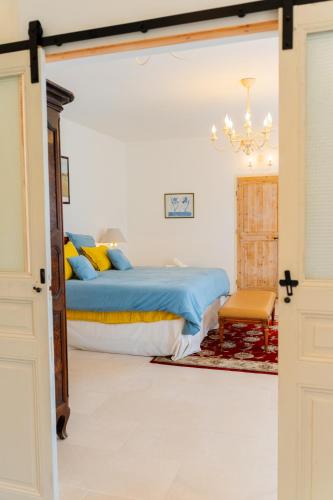 a bedroom with a bed and a chandelier at Domaine de la Cascade Parfumée in Grasse