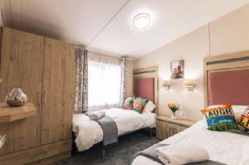 Un dormitorio con dos camas y una ventana. en Primrose Lodge with Hot Tub, en York