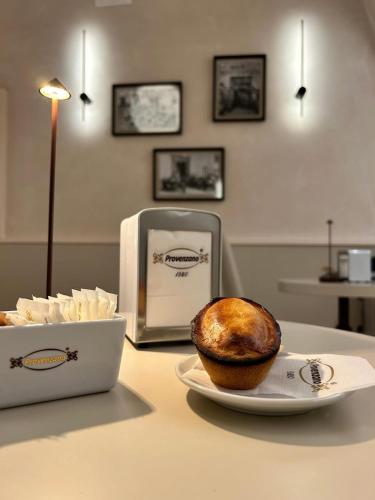 a bagel on a plate on a table with a laptop at La Casetta in Tuglie