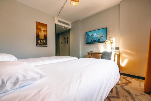 a hotel room with two beds and a chair at Hotel Base Camp Lodge - Albertville in Albertville