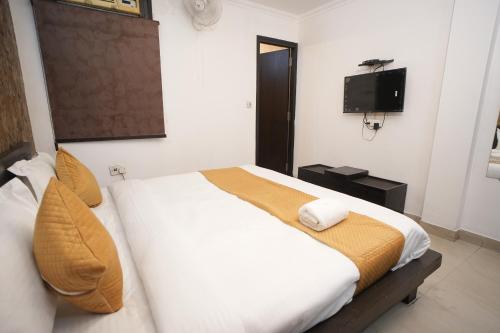 a bedroom with a large bed and a television at Golden Palm Residency in New Delhi