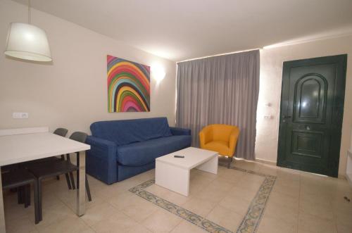 a living room with a blue couch and a table at Apartamentos Natural Park in Puerto Rico de Gran Canaria