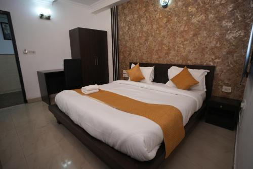 a bedroom with a large bed with orange and white pillows at Golden Palm Residency in New Delhi